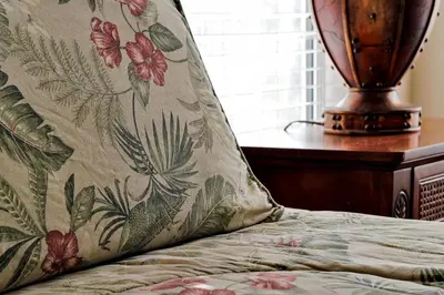 a pillow sitting on top of a bed next to a table at Mickeys Sunspot - 6 bed Emerald Island Resort pool home in Kissimmee