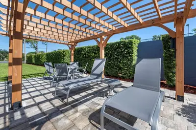 a patio with chairs and a wooden pergola at Best Western Plus Orlando East - UCF Area in Orlando