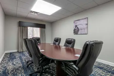 a conference room with a wooden table and black chairs at Best Western Plus Orlando East - UCF Area in Orlando