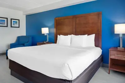 a large bed in a hotel room with a blue wall at Comfort Inn & Suites Orlando North in Sanford