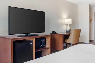 a room with a flat screen tv on a entertainment center at Comfort Inn & Suites Orlando North in Sanford