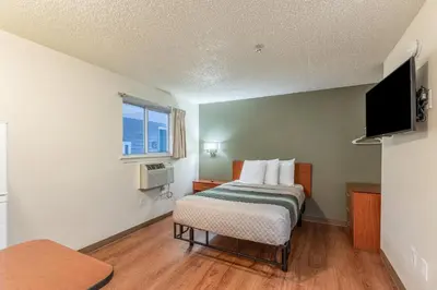 a bedroom with a bed and a television in it at HomeTowne Studios by Red Roof Orlando - Casselberry in Orlando