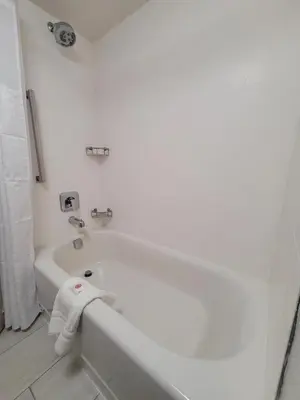 a white bathroom with a bath tub with a towel at City Express by Marriott Orlando International Drive in Orlando