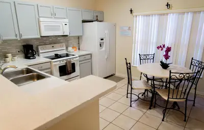 a kitchen with a sink and a table with chairs at Private Pool House With Private Pool, Near All Famous Attractions!!! in Kissimmee
