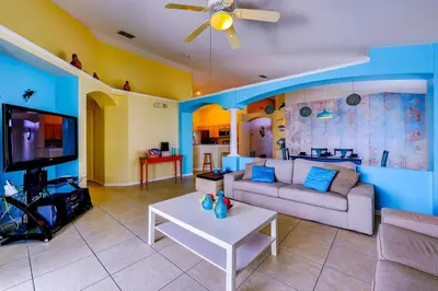 a living room with a couch and a tv at Fascinating Lake View With Private Pool And Game-Room, Near Disney!! in Kissimmee