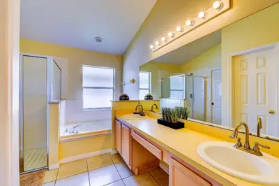 a bathroom with two sinks and a large mirror at Fascinating Lake View With Private Pool And Game-Room, Near Disney!! in Kissimmee