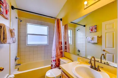 a yellow bathroom with a sink and a tub and a toilet at Fascinating Lake View With Private Pool And Game-Room, Near Disney!! in Kissimmee