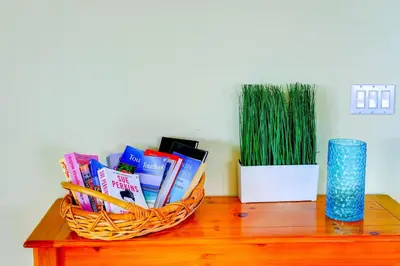 a basket of books and a vase on a table at Fascinating Lake View With Private Pool And Game-Room, Near Disney!! in Kissimmee