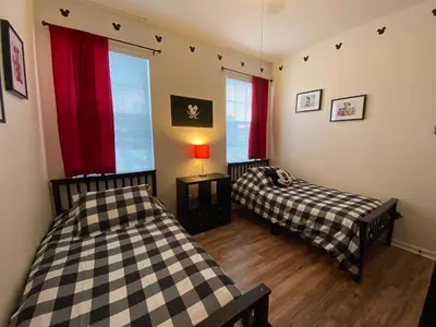 two beds in a room with two windows at Mickey Holiday Home a Windsor Palms Villa in Kissimmee