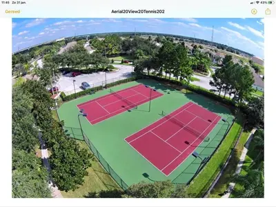 an overhead view of two tennis courts with trees at Mickey Holiday Home a Windsor Palms Villa in Kissimmee