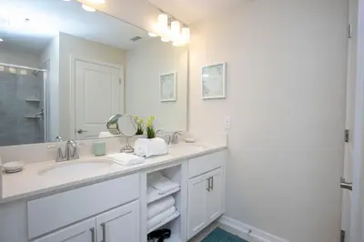 a white bathroom with a sink and a mirror at Gorgeous Two Bedroom Apto Close to Disney 306 in Kissimmee
