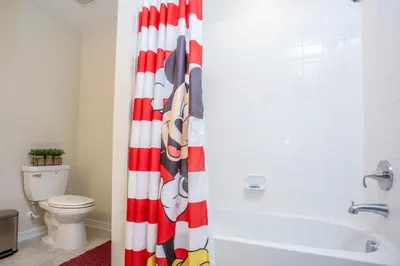 a bathroom with a red and white shower curtain at Gorgeous Two Bedroom Apto Close to Disney 306 in Kissimmee