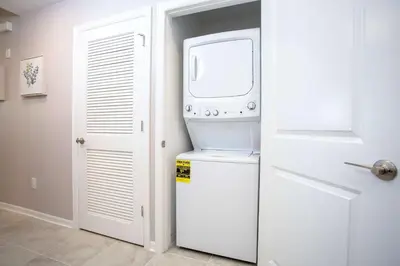 a microwave sitting on top of a refrigerator next to a door at Gorgeous Two Bedroom Apto Close to Disney 306 in Kissimmee