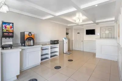 a large kitchen with white cabinets and a refrigerator at Suburban Studios International Drive in Orlando