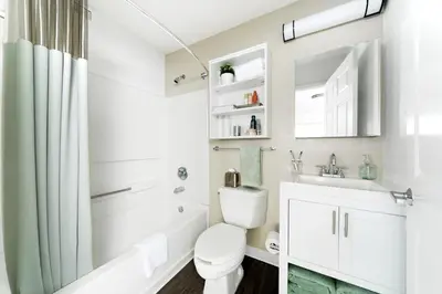 a white bathroom with a toilet and a sink at InTown Suites Extended Stay Select Orlando FL - UCF in Orlando