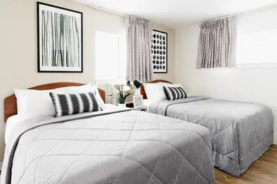 two beds in a bedroom with white walls at InTown Suites Extended Stay Select Orlando FL - UCF in Orlando