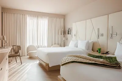 a white hotel room with two beds and a desk at ette luxury hotel & spa - Near Disney Theme Parks in Orlando