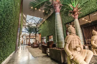 a lobby with palm trees in a building at Magic Village Views Trademark Collection by Wyndham in Orlando