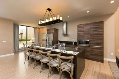 a kitchen with a large island with bar chairs at Magic Village Views Trademark Collection by Wyndham in Orlando