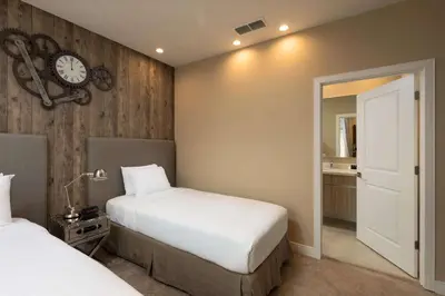 a bedroom with two beds and a clock on the wall at Magic Village Views Trademark Collection by Wyndham in Orlando