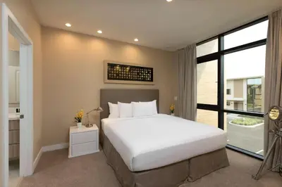 a bedroom with a white bed and a large window at Magic Village Views Trademark Collection by Wyndham in Orlando