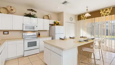 a kitchen with white cabinets and a counter top at Palm Key Villa 7 bed on Emerald Island Resort in Kissimmee