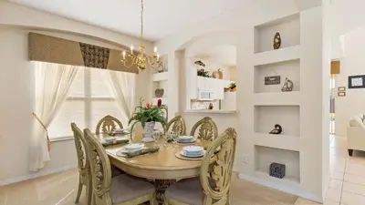 a dining room with a wooden table and chairs at Palm Key Villa 7 bed on Emerald Island Resort in Kissimmee