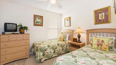 a bedroom with two beds and a tv and a dresser at Palm Key Villa 7 bed on Emerald Island Resort in Kissimmee