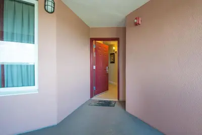 an empty hallway with a red door and a window at Beautiful Apartment close to Disney, fully equipped Amazing lake views in Orlando