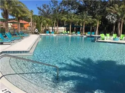 a swimming pool with blue chairs in a resort at Spectacular big house, 4 Bedrooms, private pool in Kissimmee