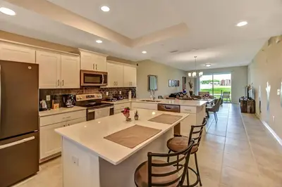 a large kitchen with white cabinets and a large island at H - New 2 Bedroom Condo - 5 Miles to Disney - Free Water Park in Kissimmee