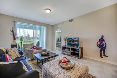 a living room with a superhero statue on the wall at H - New 2 Bedroom Condo - 5 Miles to Disney - Free Water Park in Kissimmee