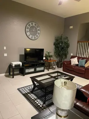 a living room with a couch and a clock on the wall at Windsor Hills Resort 5BR Villa, Amenities, Private Pool & Water Park, Near Disney, Sea World, Universal in Orlando