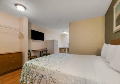 a hotel room with a bed and a television at HomeTowne Studios by Red Roof Orlando - UCF Area in Orlando