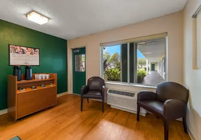 a waiting room with two chairs and a window at HomeTowne Studios by Red Roof Orlando - UCF Area in Orlando
