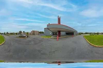 a building with a car parked in a parking lot at OYO Hotel Orlando Airport in Orlando