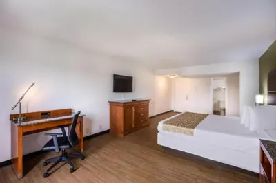 a hotel room with a bed and a desk with a computer at OYO Hotel Orlando Airport in Orlando