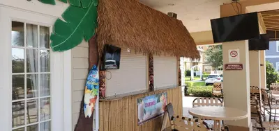 a restaurant with a table and a straw roof at Kissimmee 3bed Villa Near Disney in Kissimmee