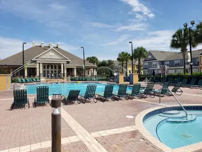 a swimming pool with lounge chairs and a building at Kissimmee 3bed Villa Near Disney in Kissimmee