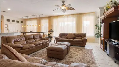 a living room with two couches and a television at Mickeys Maingate Mansion in Kissimmee
