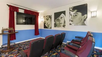 a waiting room with chairs and posters on the wall at Mickeys Maingate Mansion in Kissimmee