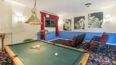 a living room with a pool table and chairs at Mickeys Maingate Mansion in Kissimmee