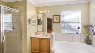 a bathroom with a tub and a sink and a shower at Mickeys Maingate Mansion in Kissimmee