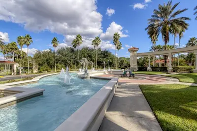 a fountain in a park with palm trees at Mickeys Maingate Mansion in Kissimmee