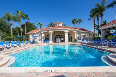 a swimming pool with chairs and a house at Mickeys Maingate Mansion in Kissimmee