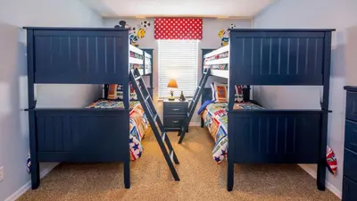 two bunk beds in a room with two beds at Minnie and Mickeys Mansion - Emerald Island in Kissimmee