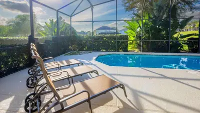 a group of chairs sitting next to a swimming pool at Minnie and Mickeys Mansion - Emerald Island in Kissimmee