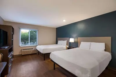 a hotel room with two beds and a window at WoodSpring Suites Orlando North - Maitland in Orlando