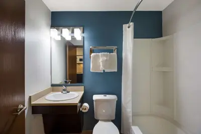 a bathroom with a toilet and a sink and a tub at WoodSpring Suites Orlando North - Maitland in Orlando