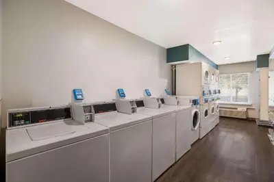 a laundry room with a row of washing machines at WoodSpring Suites Orlando North - Maitland in Orlando
